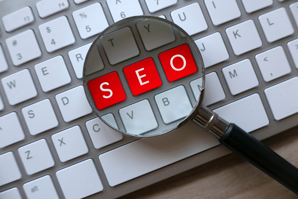 selective focus of magnifying glass and computer keyboard with red key written with seo search engine t20 G0K84w